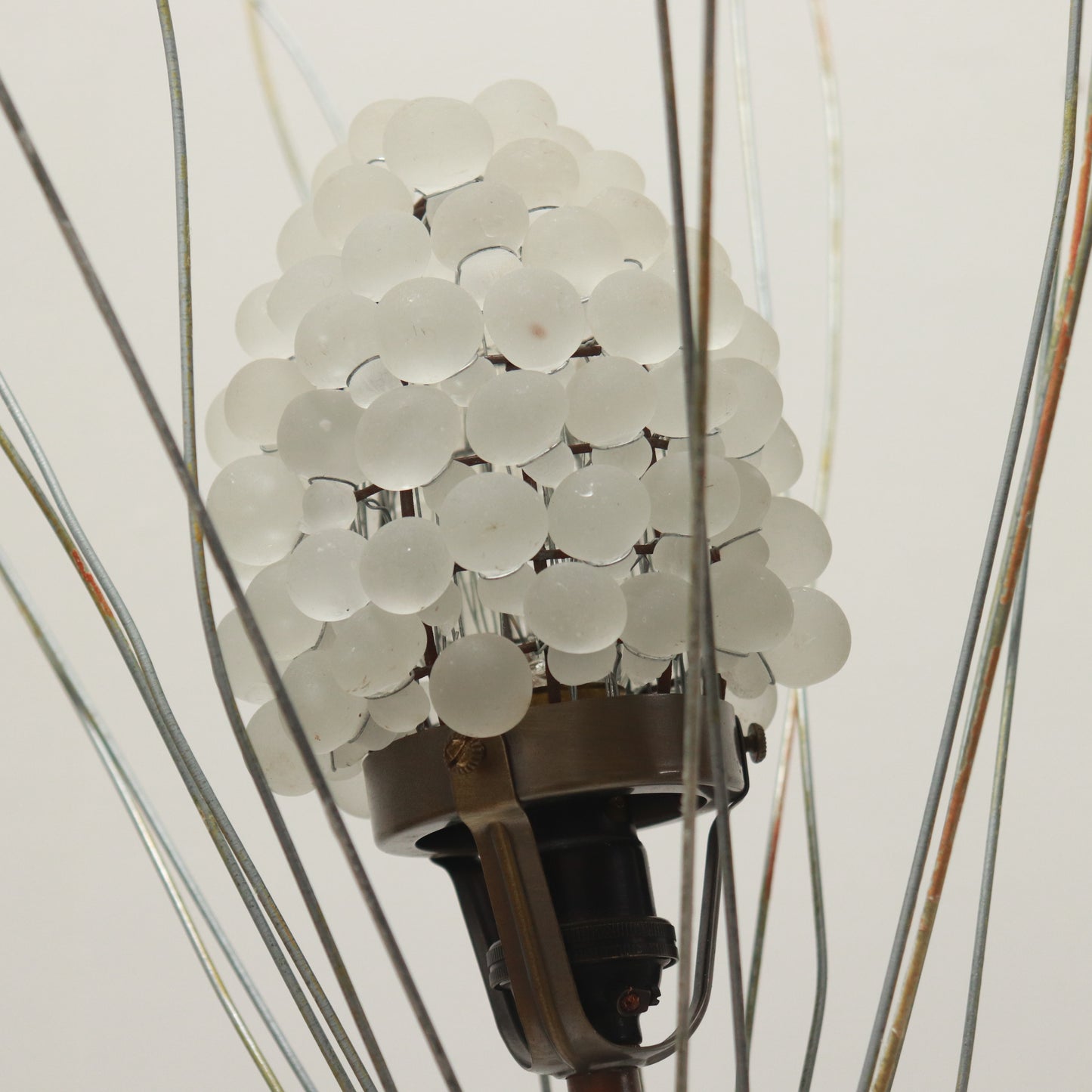 Wirework crown surrounding glass shade on mid-century lamp