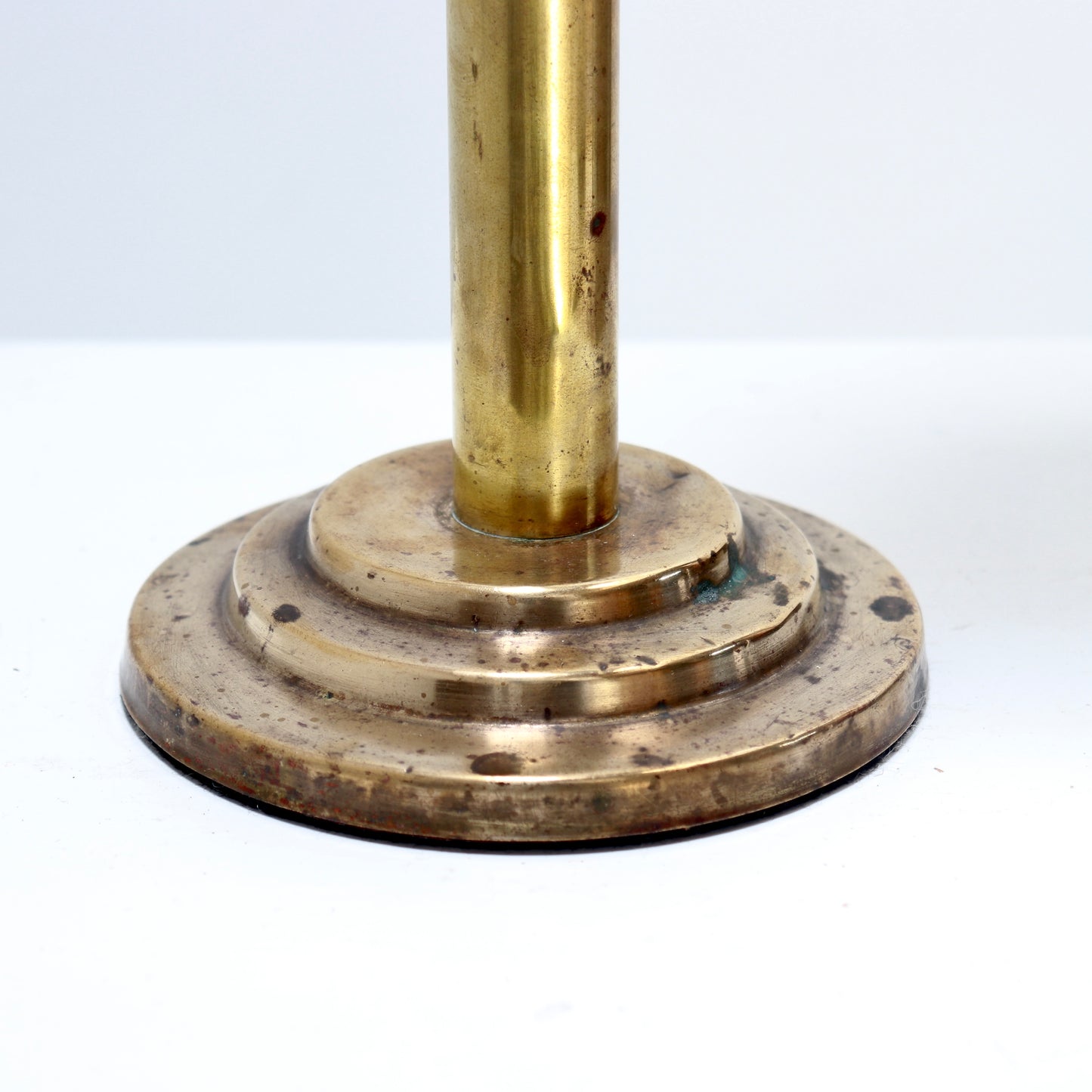Brass pedestal with a round base on a white background
