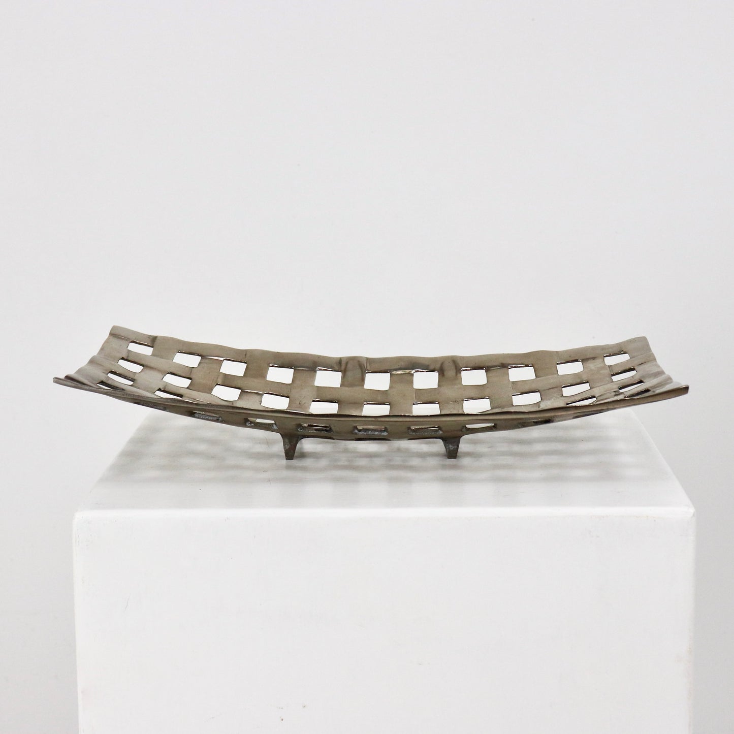 Sculptural aluminium lattice bowl shown as tabletop centrepiece