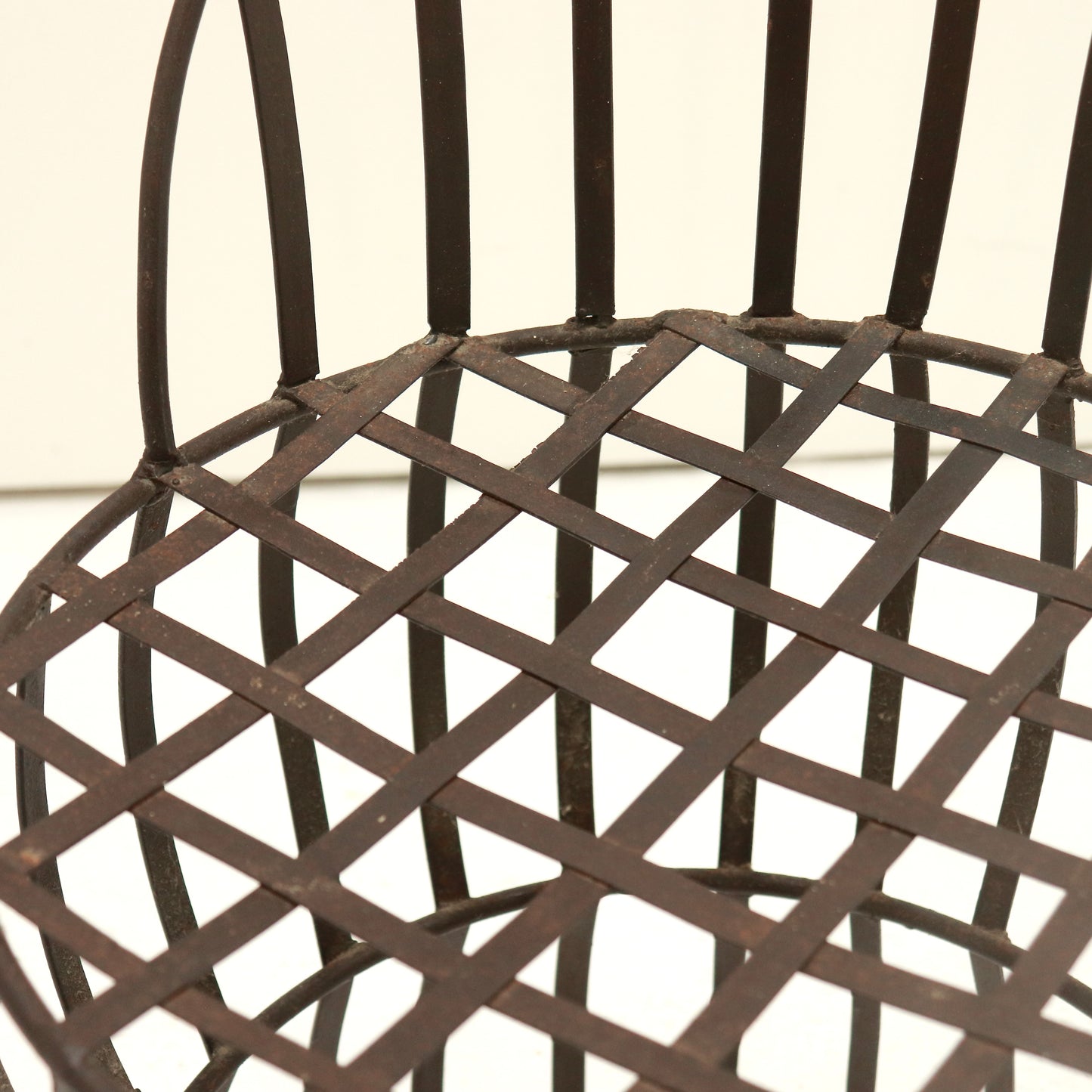 Close-up of riveted lattice seat with time-softened patina.
