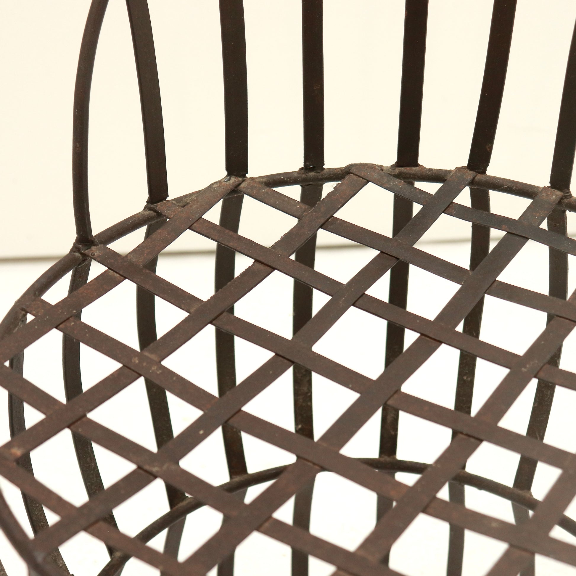 Close-up of riveted lattice seat with time-softened patina.