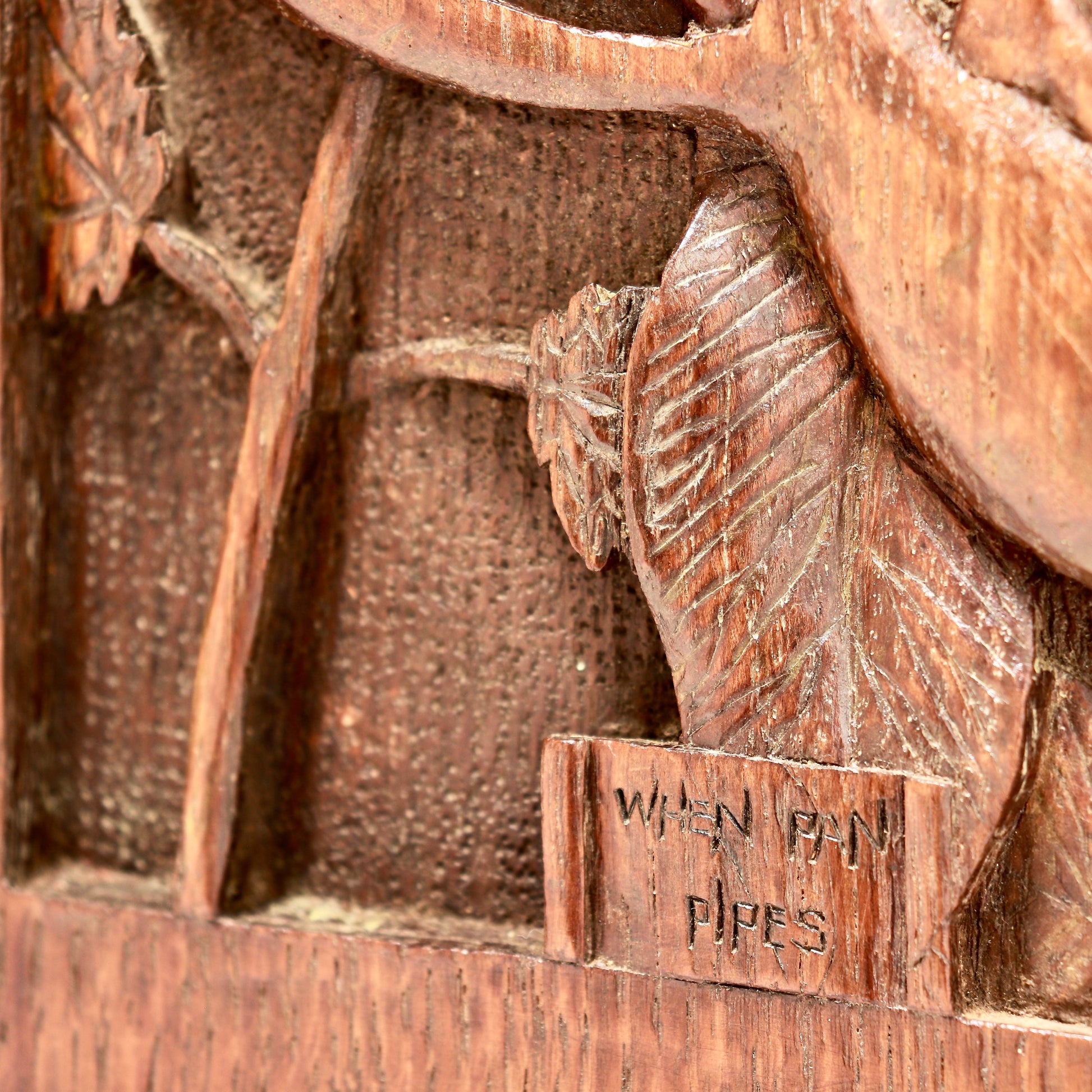 Detail of carved fairy panel with inscription “When Pan Pipes”