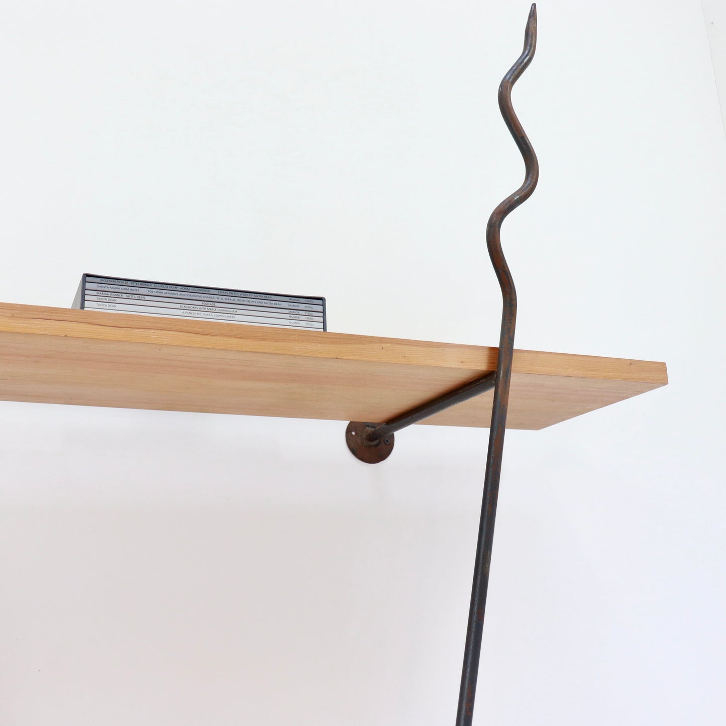 Detail of hammered iron finial above the top shelf.