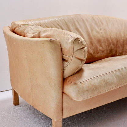 “Side view of Danish leather sofa with slim beech legs.”