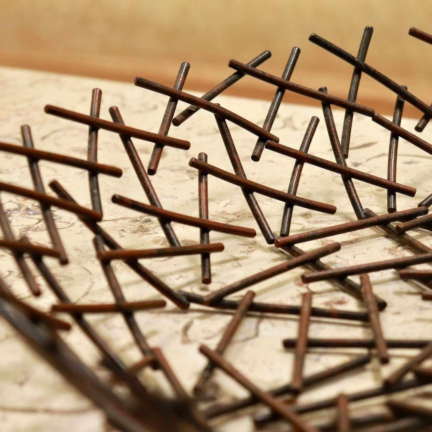 “Close-up of welded lattice detail on sculptural bowl”