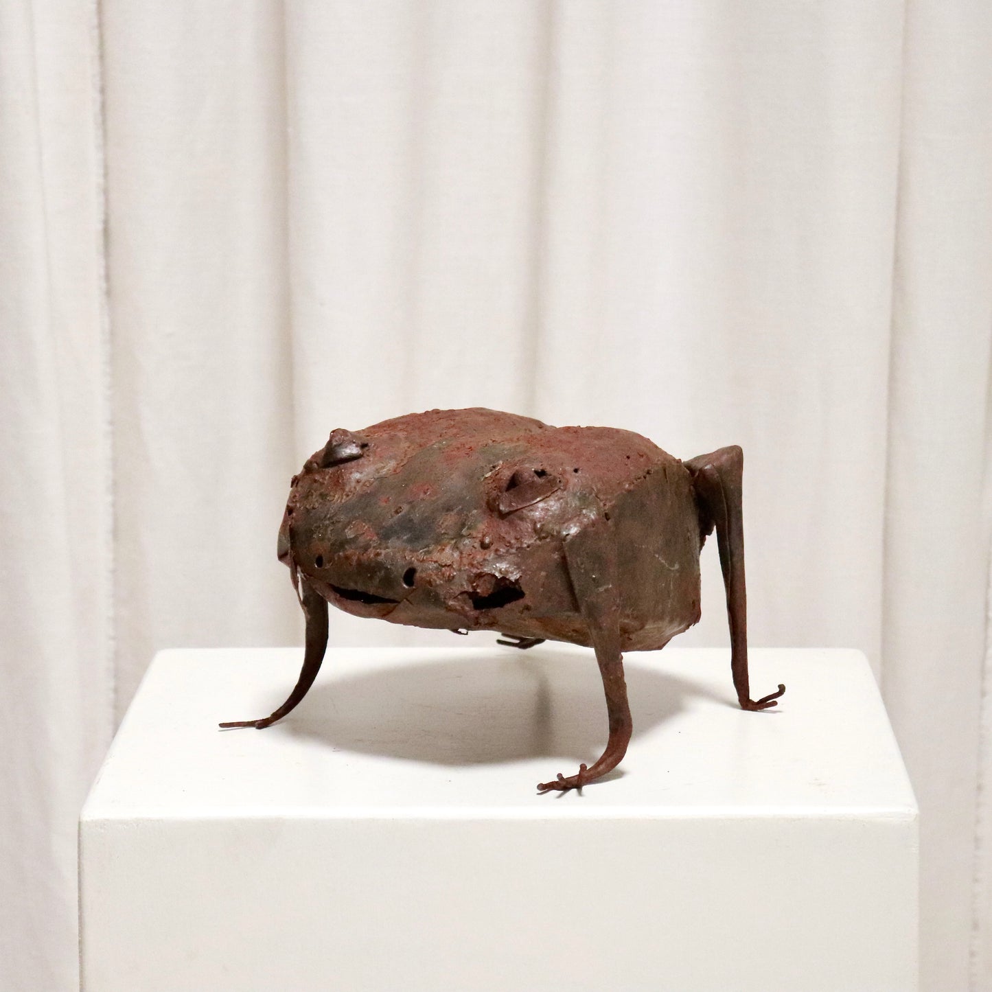 Three-quarter view showing spindly legs and patina.