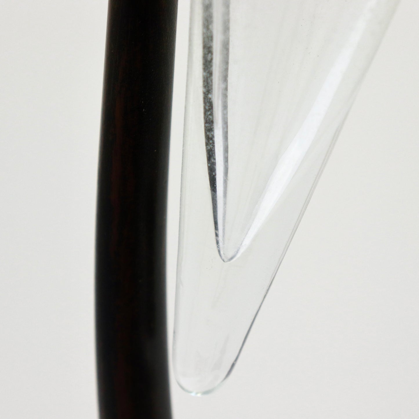 Tip of glass cone against slender iron stem, detail.