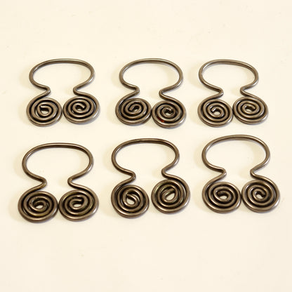 Set of six decorative spiral napkin holders.