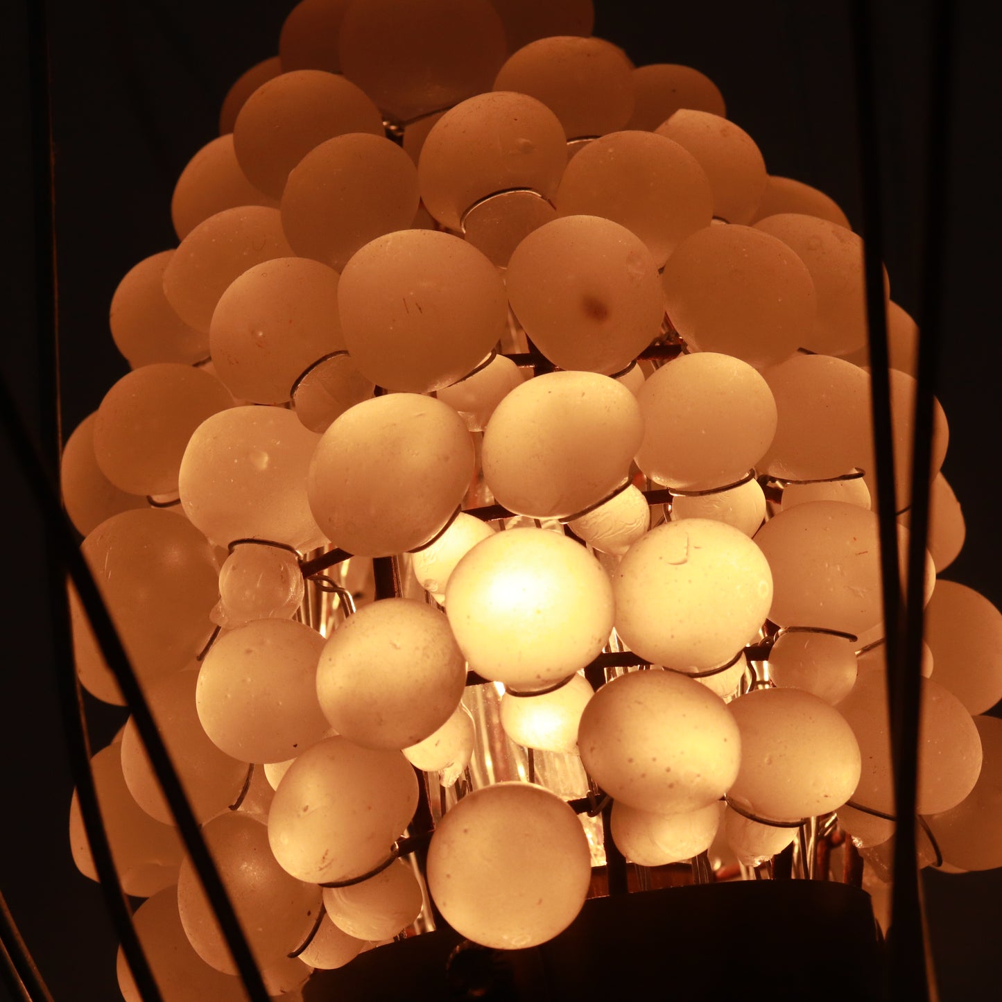Lamp illuminated showing warm glow through glass spheres