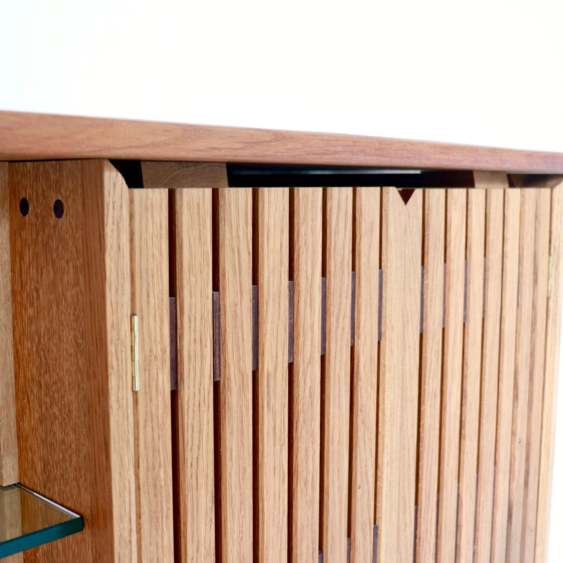 Detail of slatted timber cabinet door on oak sideboard