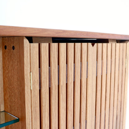 Detail of slatted timber cabinet door on oak sideboard