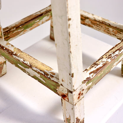 Vintage stool showing distressed finish and exposed wood grain