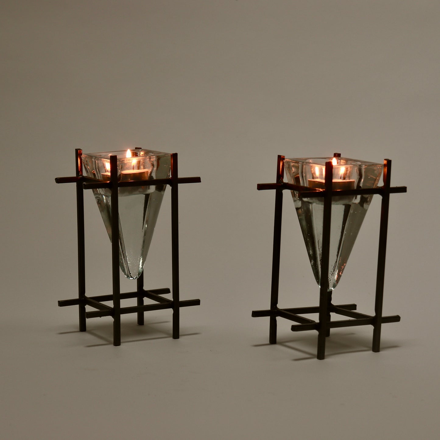 Brutalist metal and glass tealight holders lit with candles
