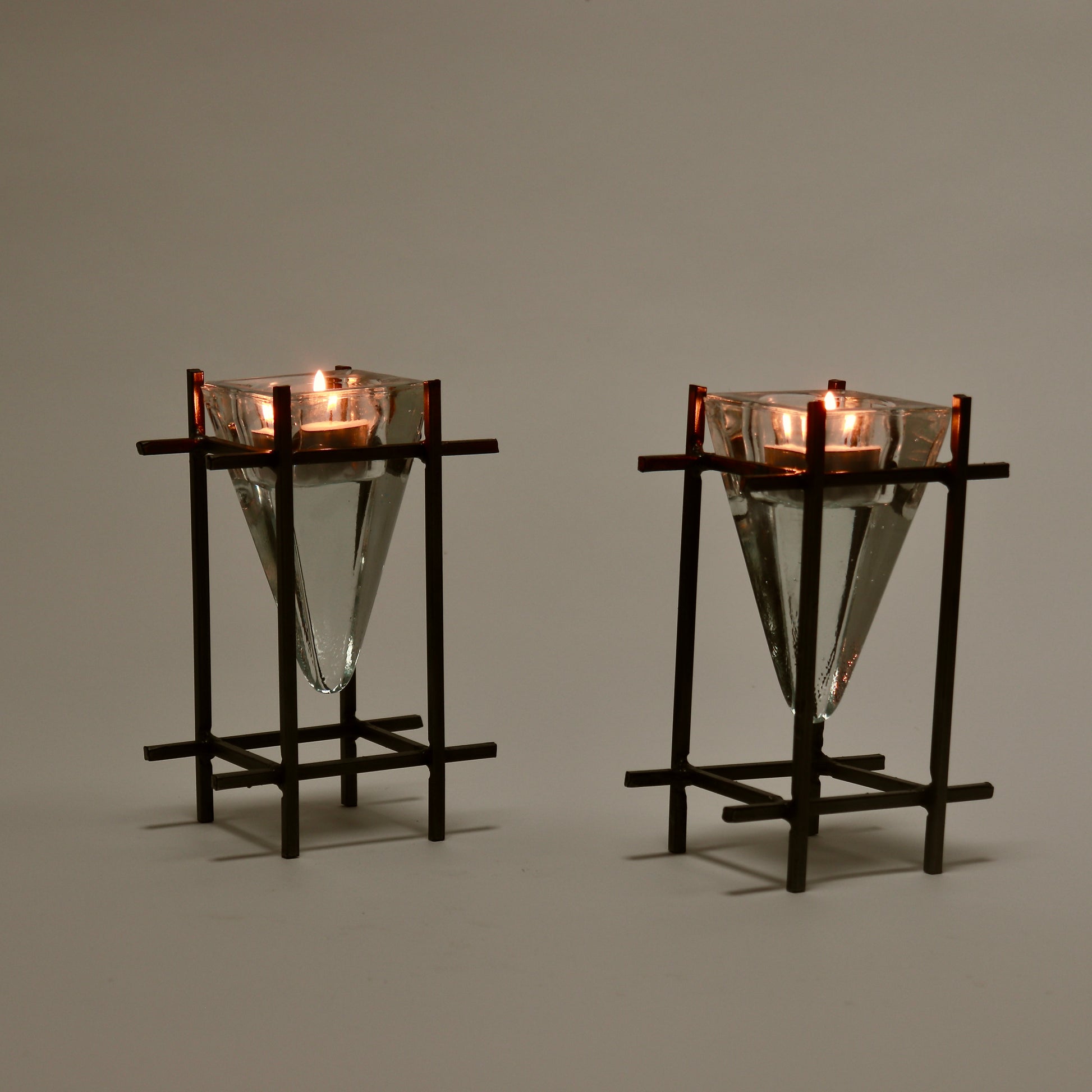 Brutalist metal and glass tealight holders lit with candles