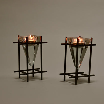 Brutalist metal and glass tealight holders lit with candles