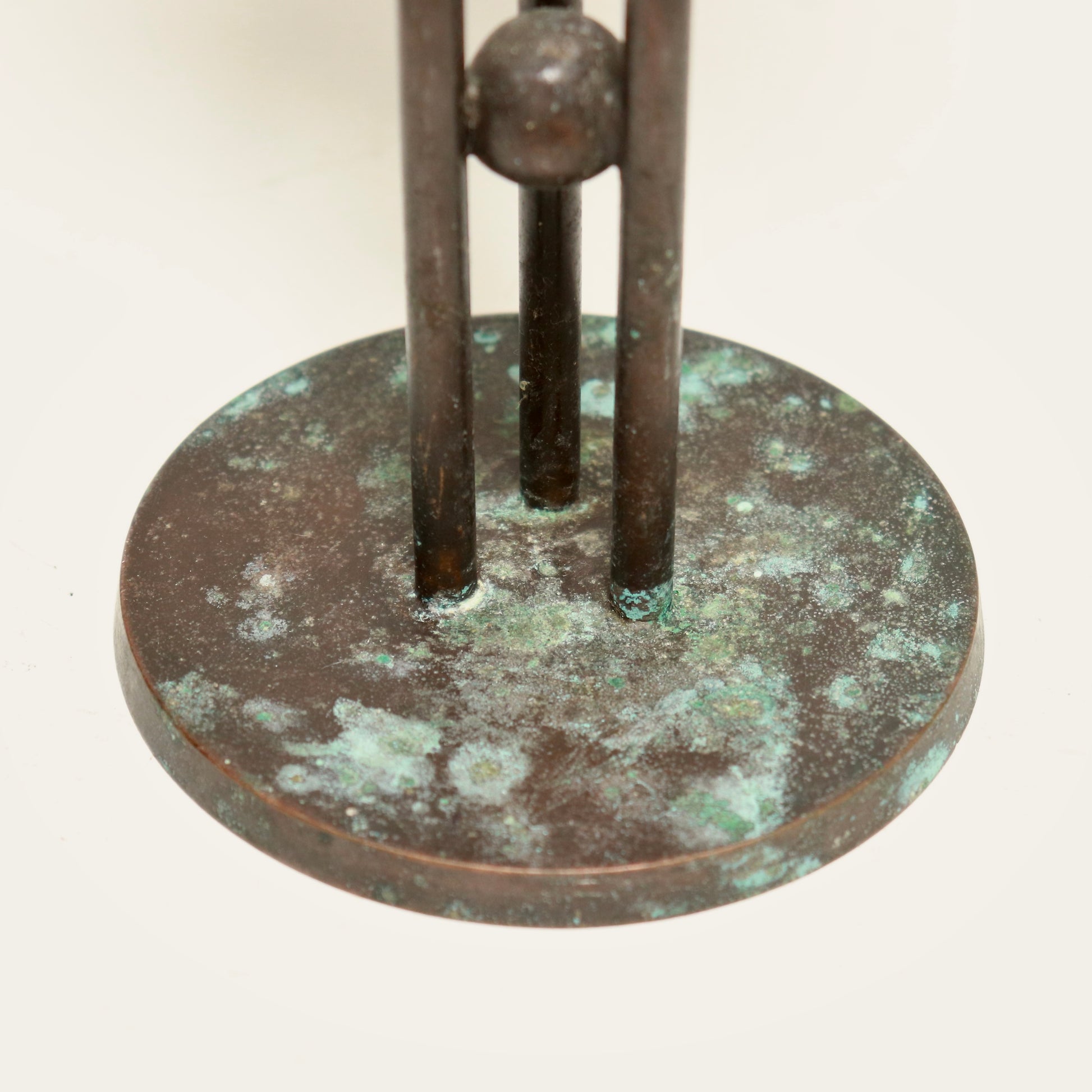 Postmodern bronzed candlestick with verdigris on circular base.