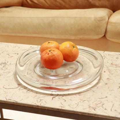 Glass dish styled with oranges on coffee table