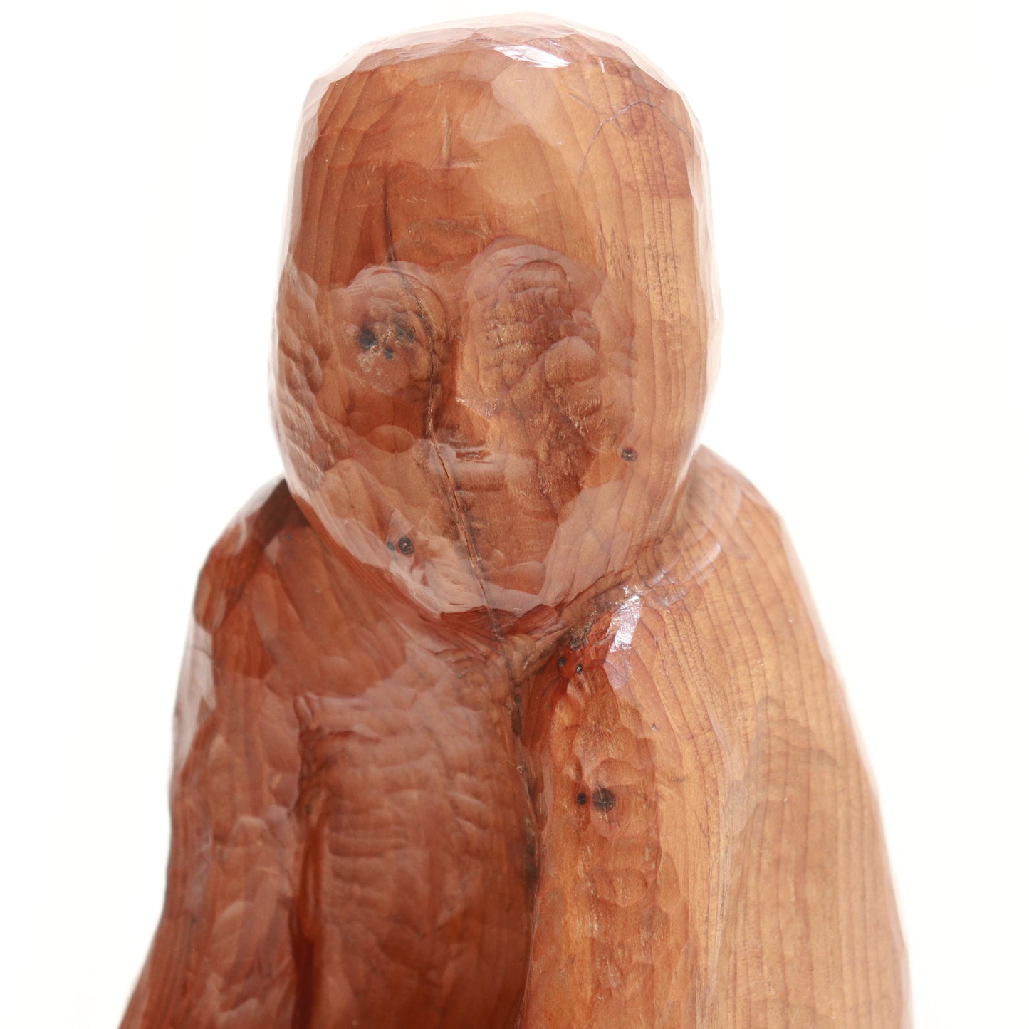 “Close-up of faceted face with visible gouge marks on wooden figure”