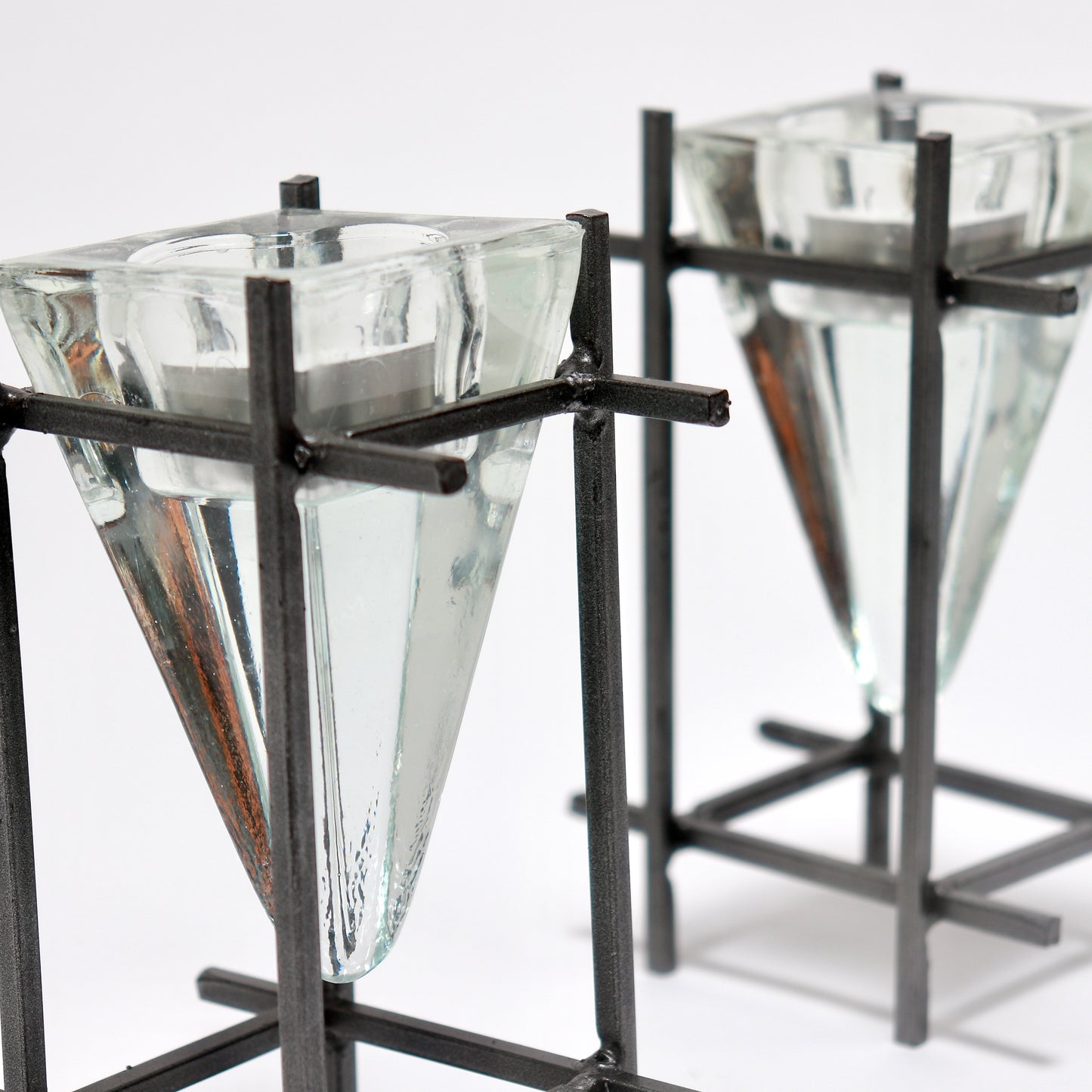 Sculptural steel frame candle holders with inverted glass prism