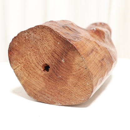 “Underside and base of vintage carved wooden figure showing tool marks”