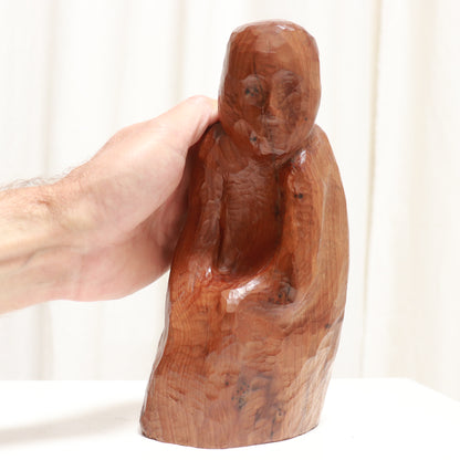 “Scale in hand showing small size of vintage carved wood sculpture”
