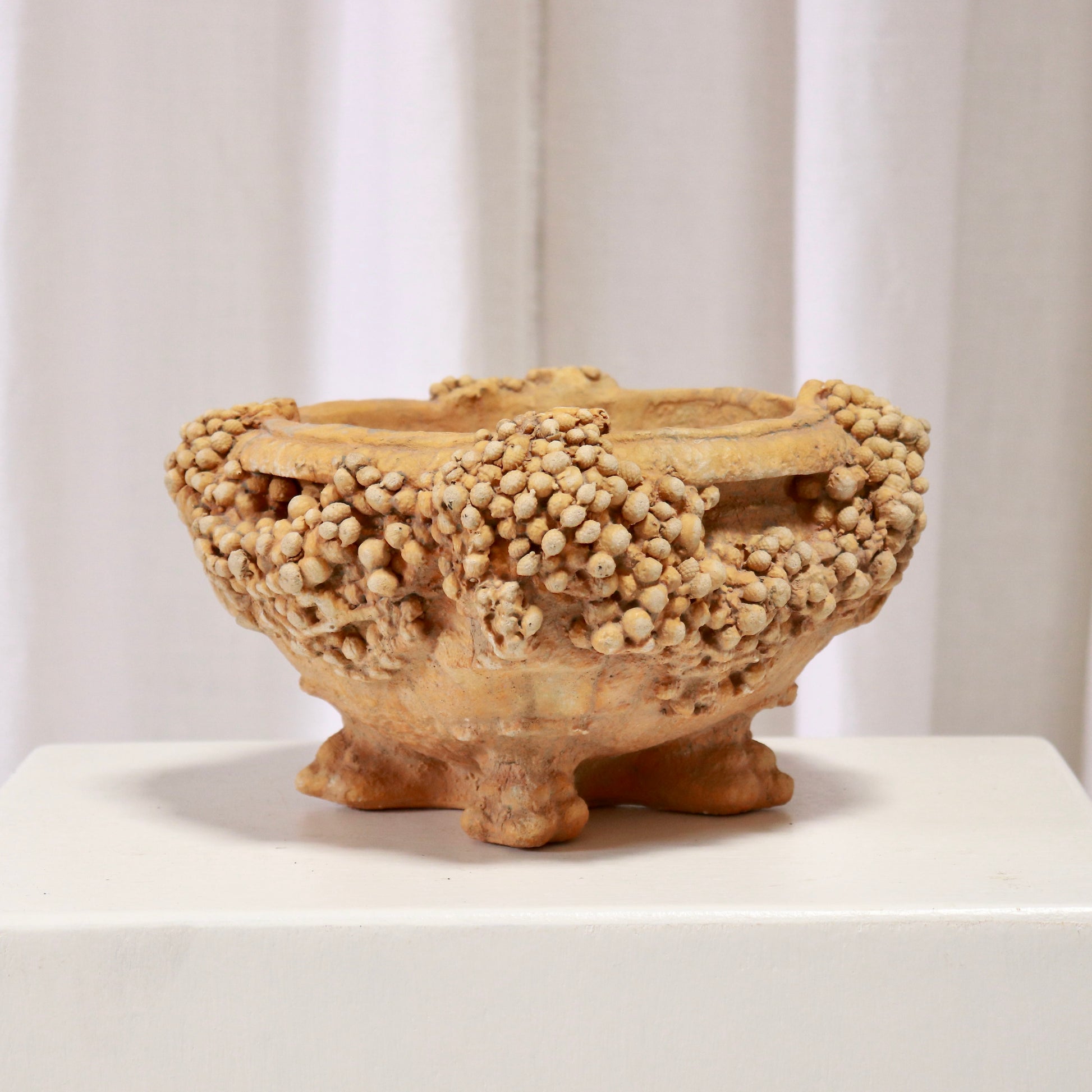 1998 cast bowl by American studio H. Parker. Encrusted, barnacle-like rim on four feet; ochre, archaeological feel. Sculptural centrepiece.