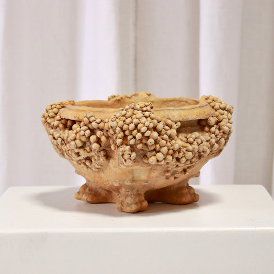 1998 cast bowl by American studio H. Parker. Encrusted, barnacle-like rim on four feet; ochre, archaeological feel. Sculptural centrepiece.