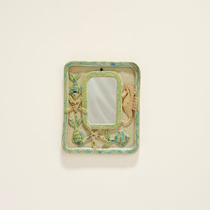 “Vintage ceramic mirror with relief seahorse and fish, front view”
