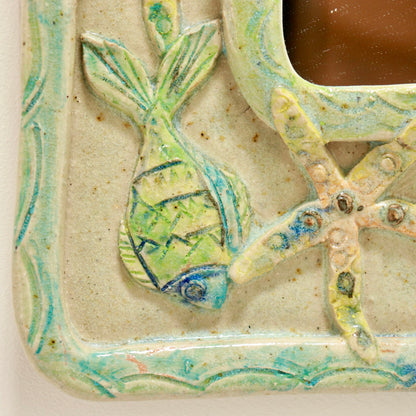 “Close-up of fish and starfish relief on folk art mirror”