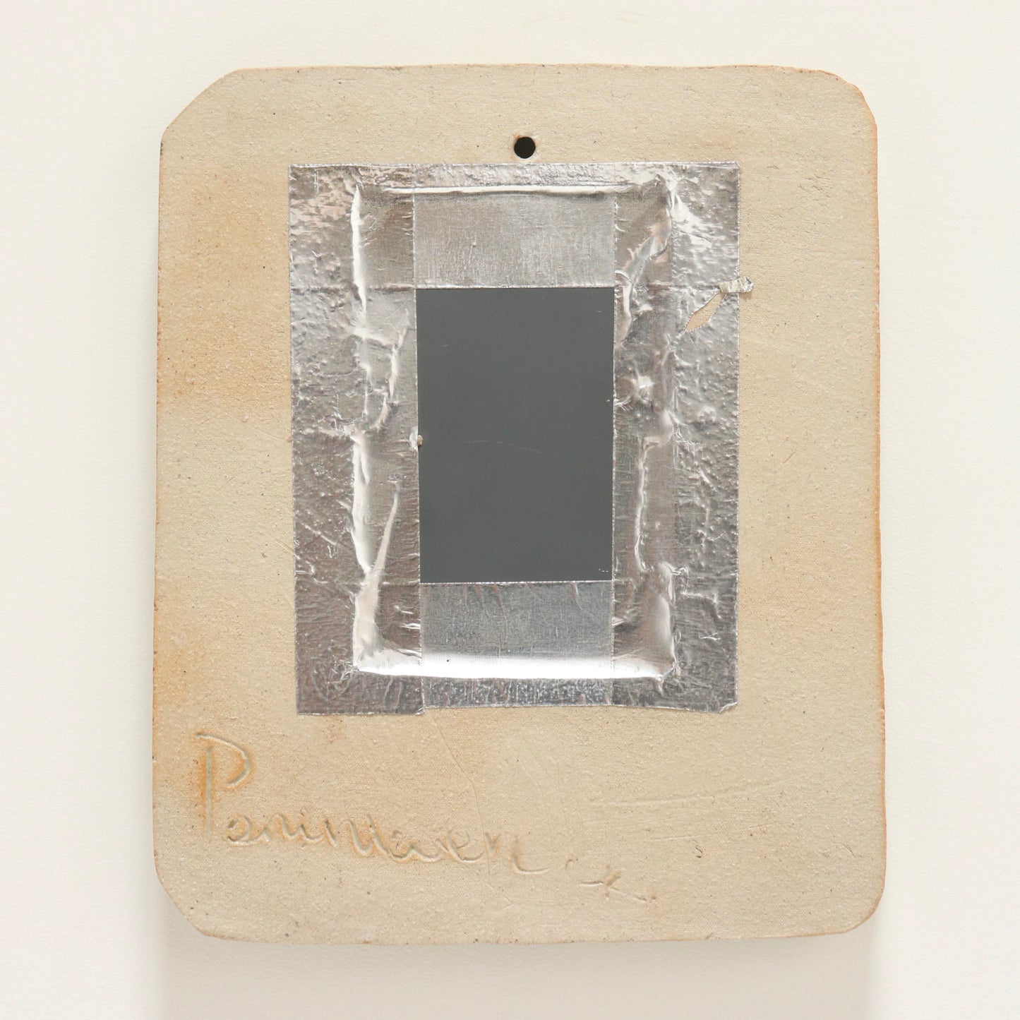 “Rear of mirror showing incised signature and fixing”