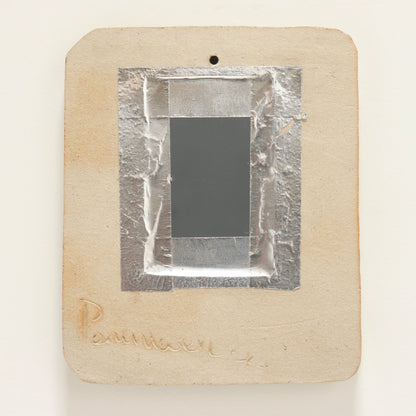 “Rear of mirror showing incised signature and fixing”